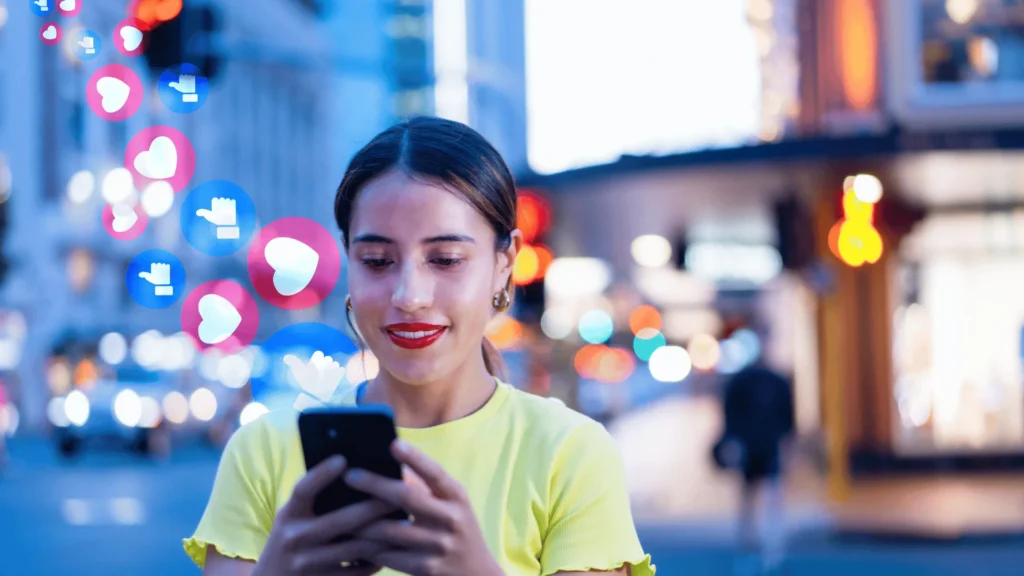 Woman using a smartphone with floating social media engagement icons in a city setting.